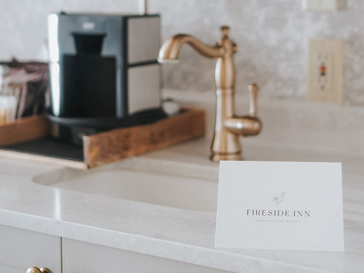 A kitchen counter with a coffee machine, sink, and a card reading "Fireside Inn."