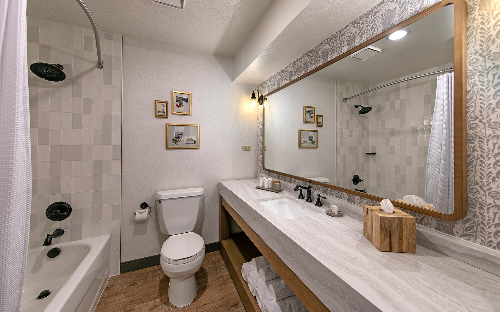 A clean bathroom with a shower, bathtub, toilet, and sink.