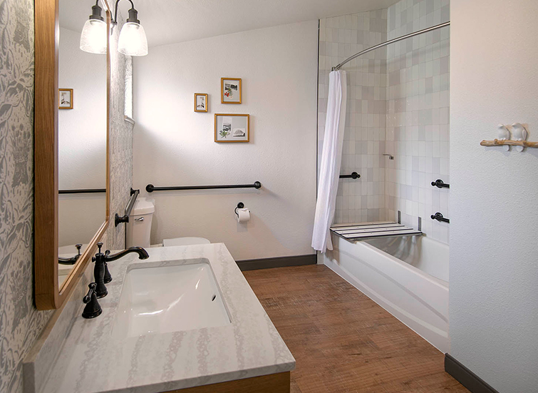 A clean bathroom with a sink, toilet, shower, and tub.